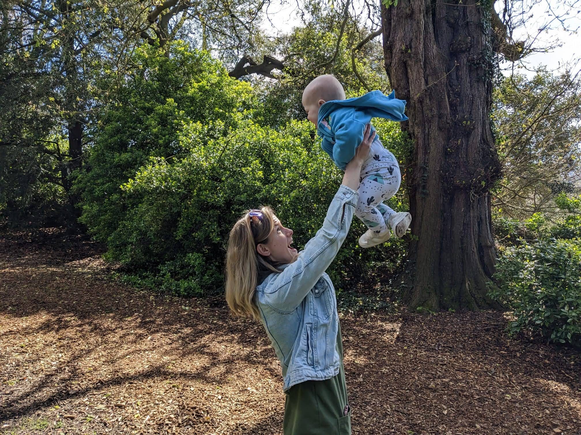 Woman lifting baby up into the air