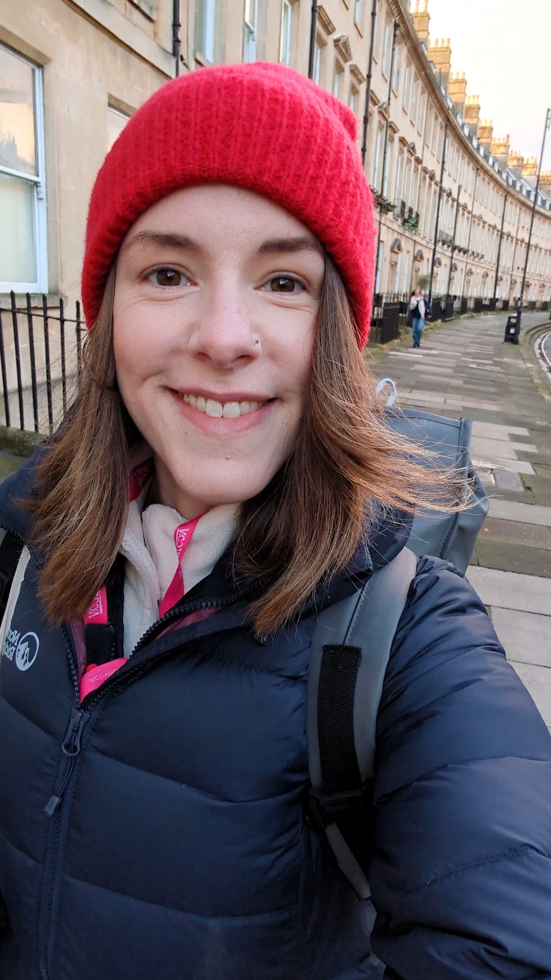 Woman smiling at camera while walking on a street